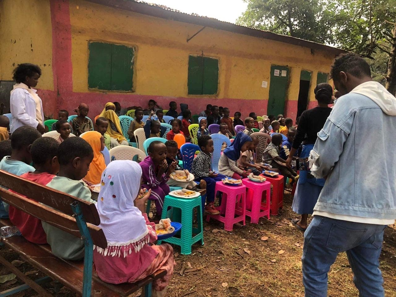 Children sharing a school meal outdoors in Jimma, Ethiopia