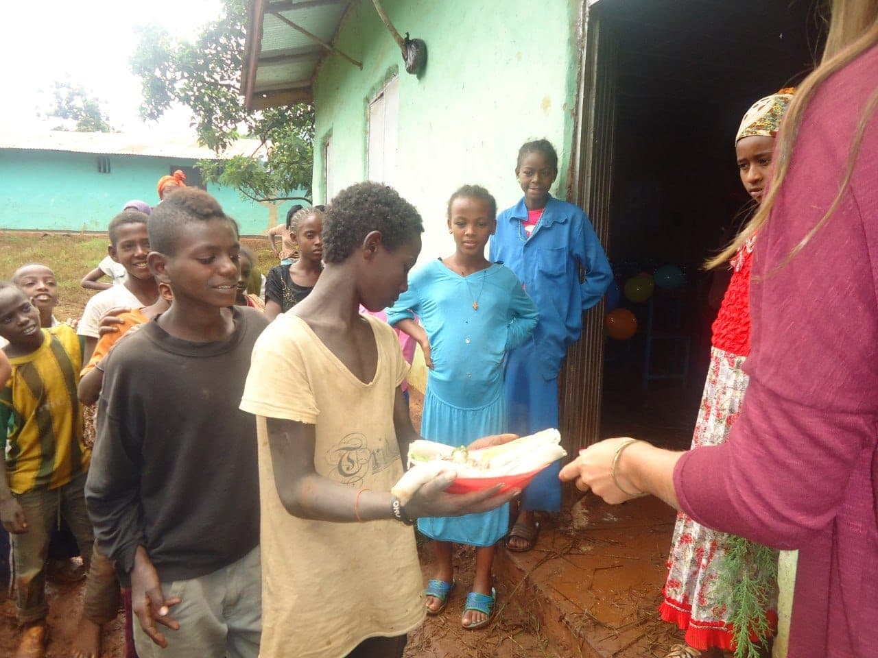 Children receiving bread from volunteers