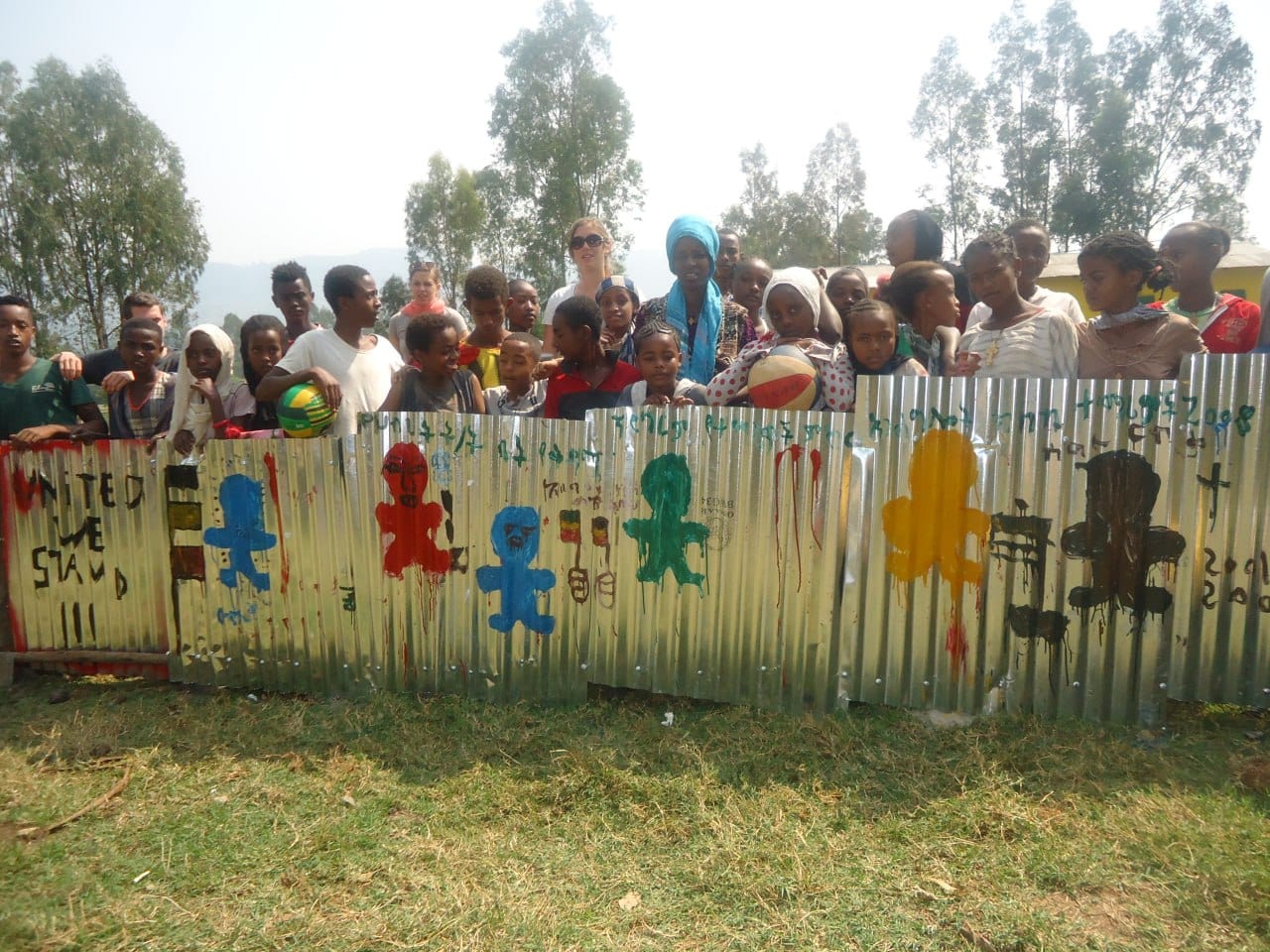 Pupils and volunteers with the painted fence